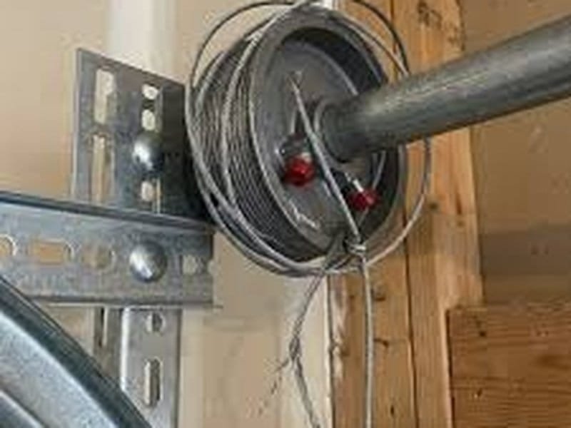 Garage door lift cable wound on the drum next to the end bearing plate