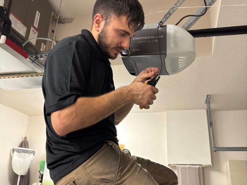 Technician servicing a ceiling-mounted garage door opener
