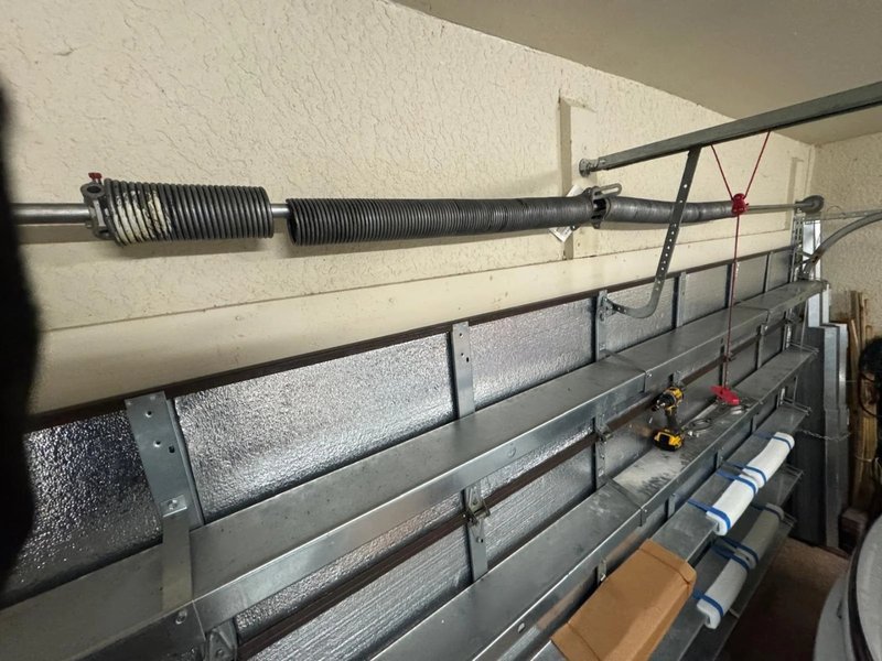 Torsion spring and drum on the shaft of a metal garage door