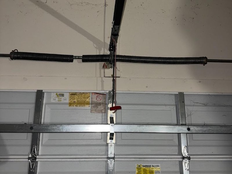Two torsion springs mounted on the shaft above a sectional garage door