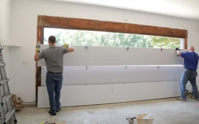 Technicians installing a modern, insulated garage door in a residential garage, showcasing quality craftsmanship for SISI Garage Door Repair Naples.